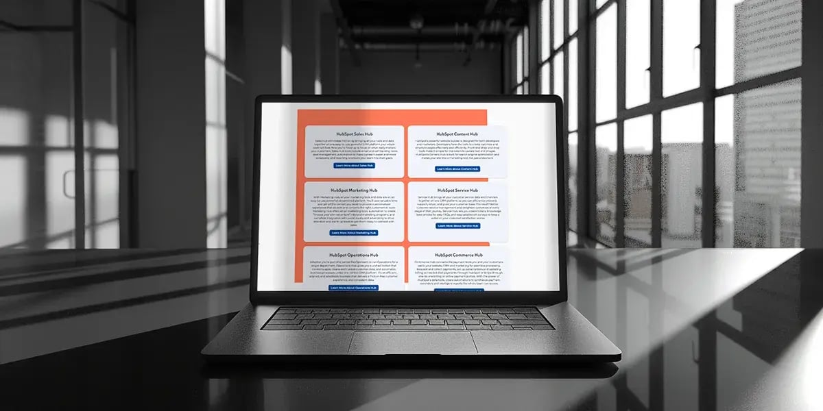 laptop with explanations of hubspot hubs on shiny black table in industrial office with windows