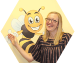 A profile picture of Liz Brown standing in front of a bee and smiling