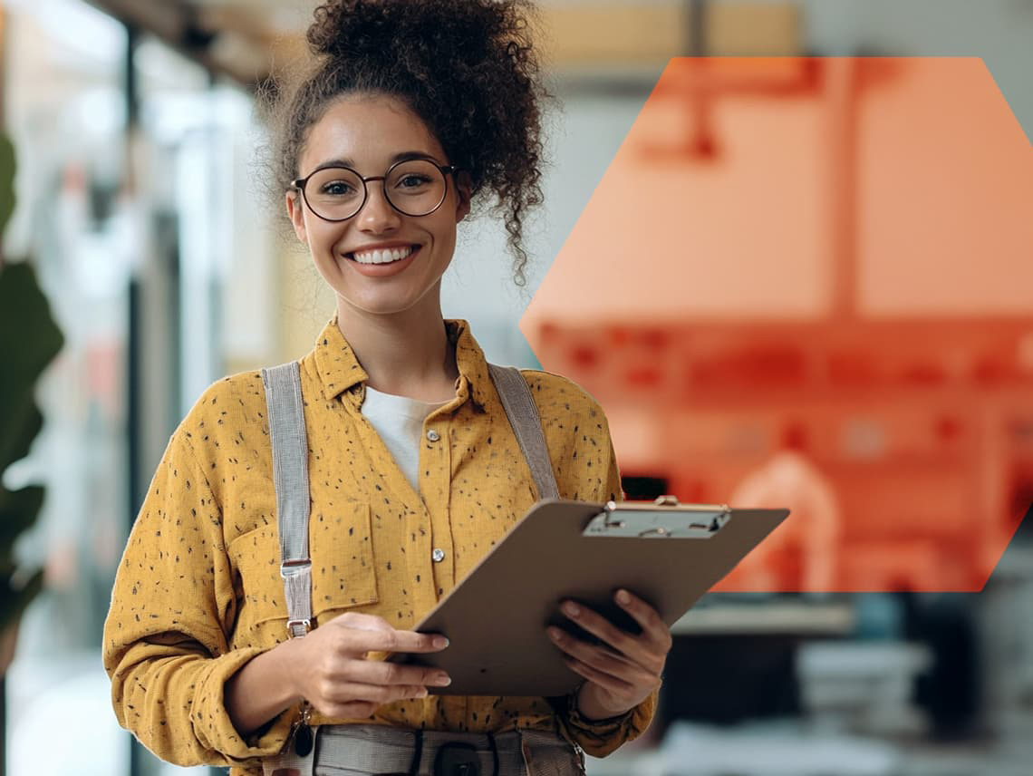 a digital marketer holding a clipboard. she smiles at the camera.