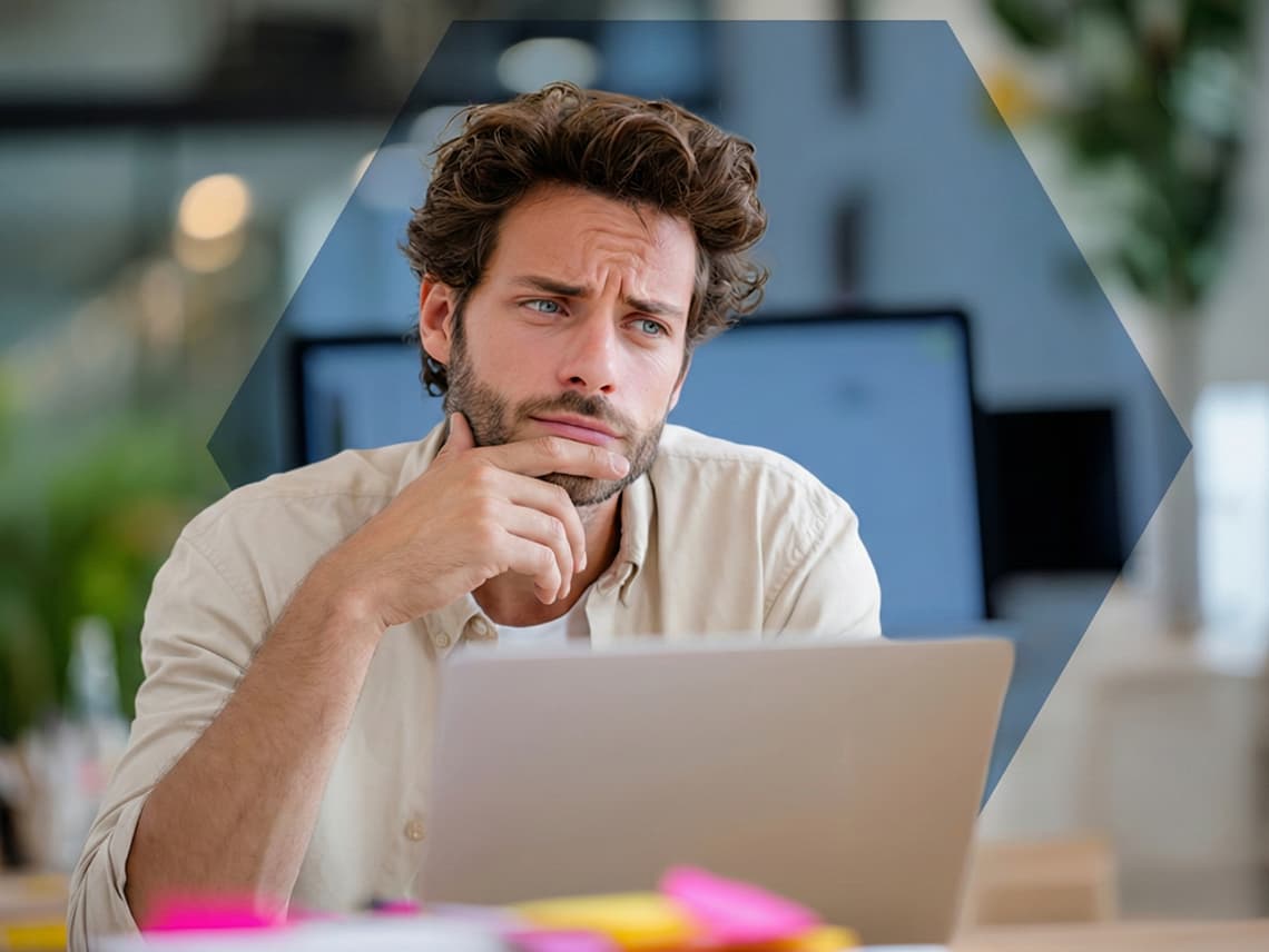 a sales person looking pensively at his computer, representing uncertainty around lead quality